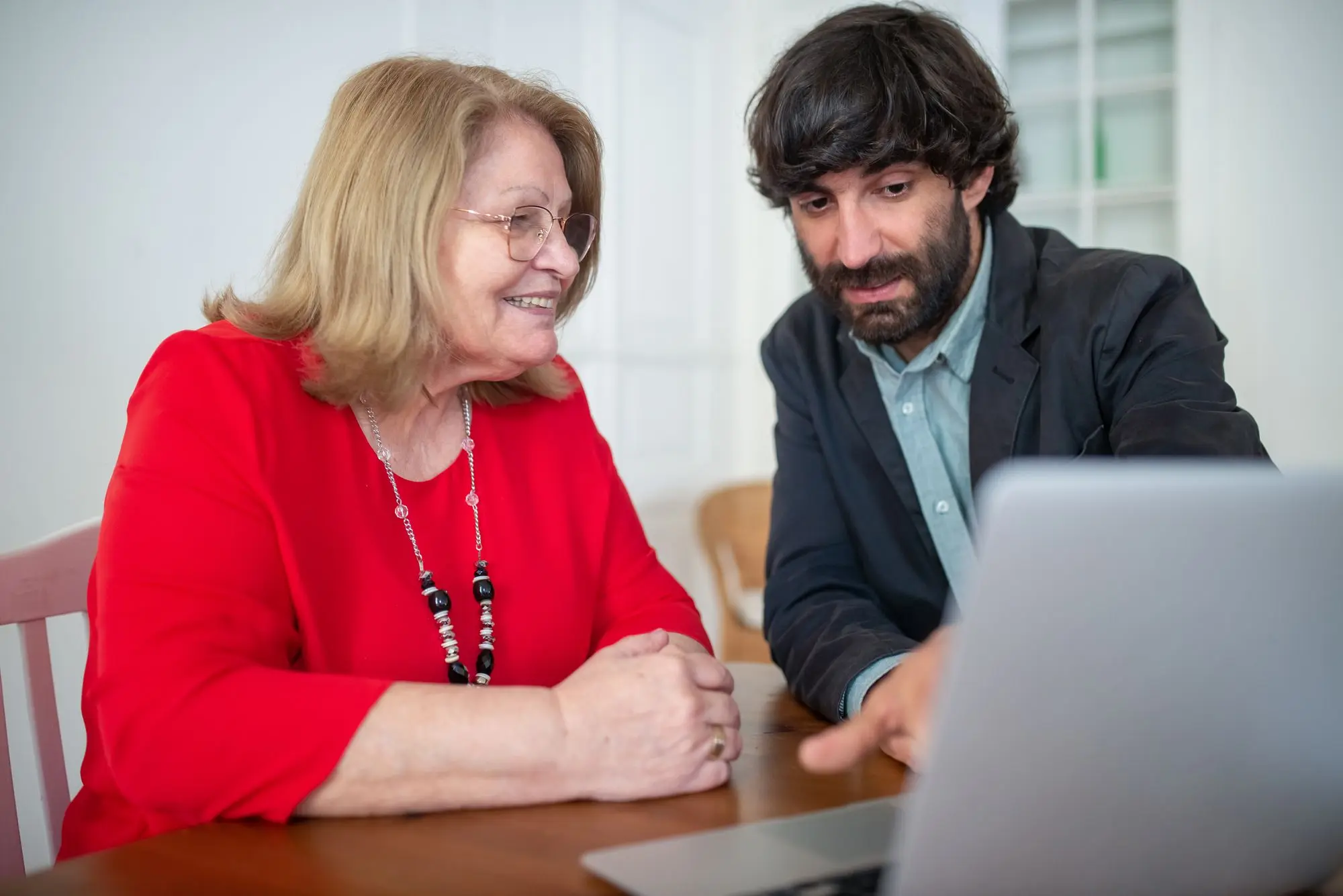 IT specialist helping a business owner at a laptop